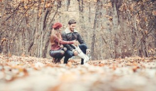 Couple playing with their dog in the woods